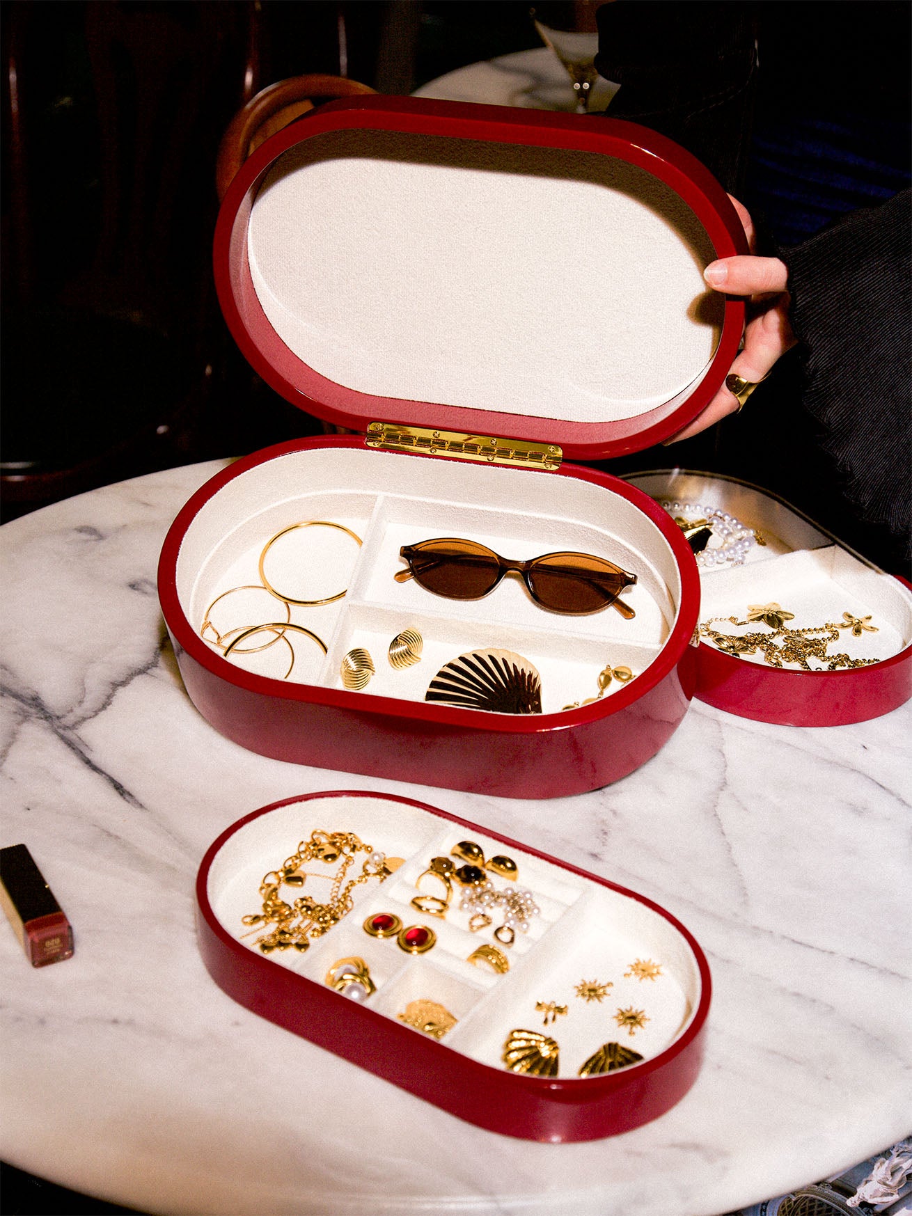 Rött smyckeskrin från misou som hålls upp