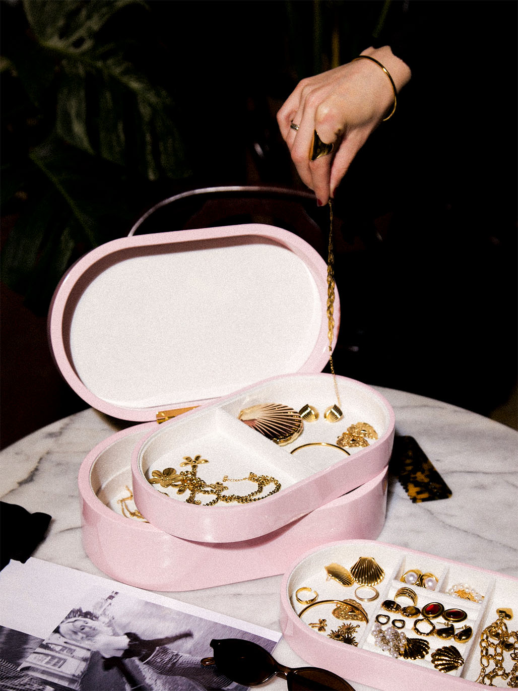 Rosa smyckeskrin från misou på marmor bord med en hand