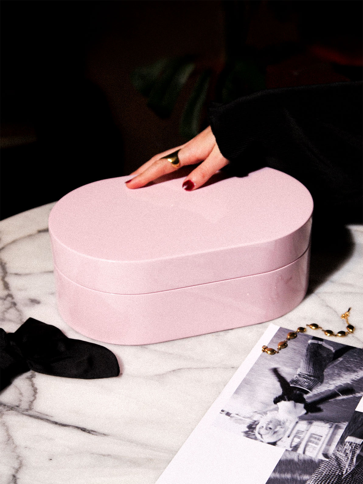 Rosa smyckeskrin från misou med en hand på