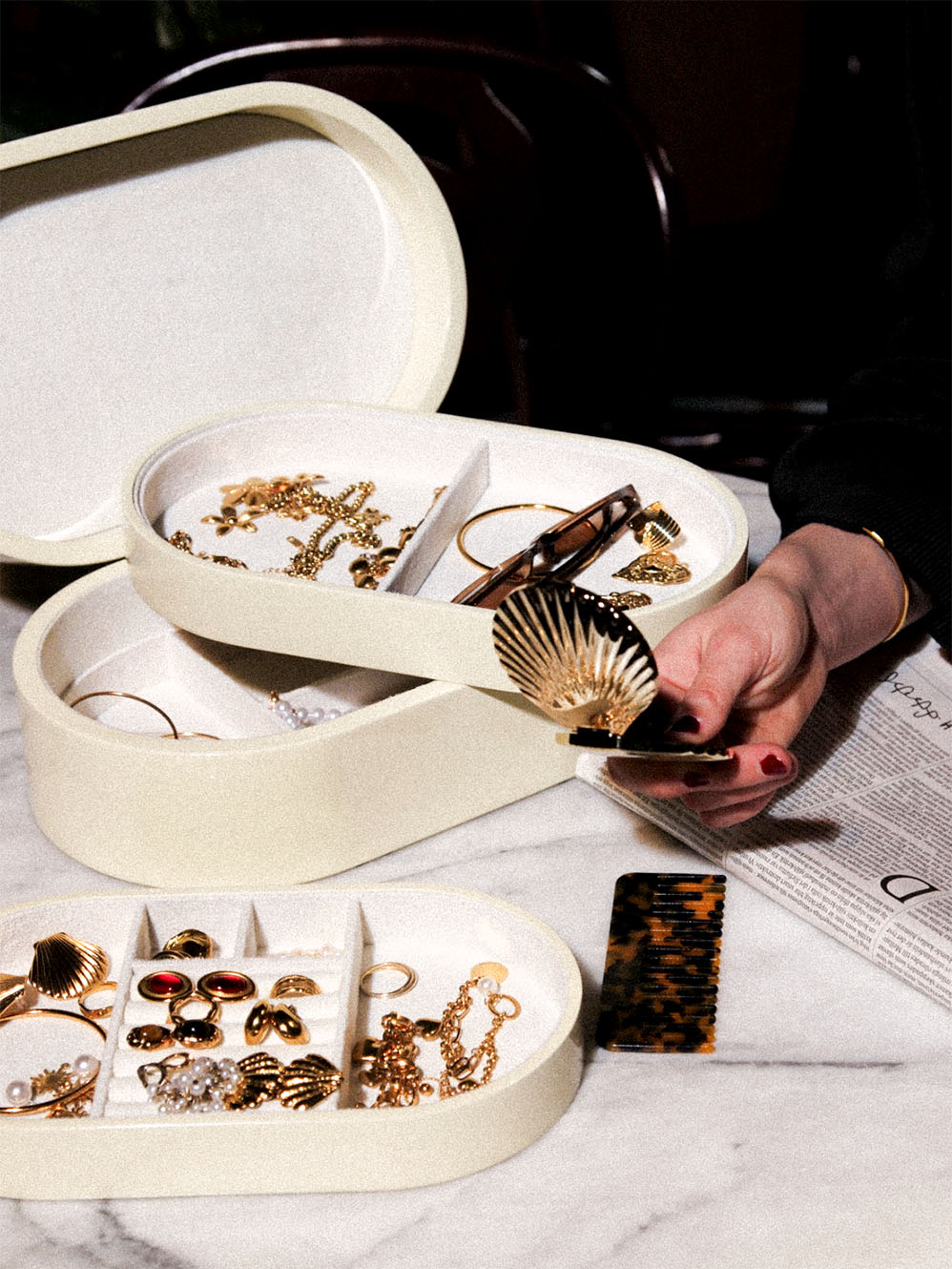 Vitt smyckeskrin från misou med en hand och smycken